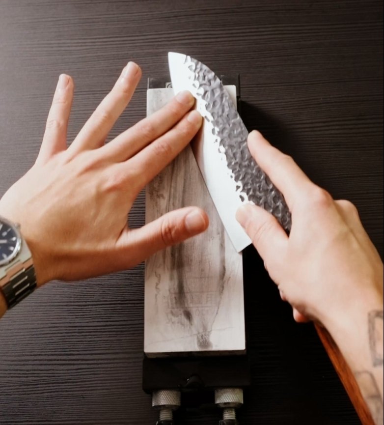 Cuchillo japonés sobre piedra mostrando la geometría durante el afilado